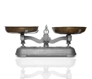 Balanza de dos platos de metal antigua sobre una superficie clara