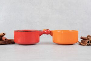 Dos tazas de cafe identicas sobre una superficie de marmol