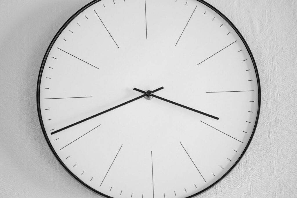 Reloj de pared blanco y negro marcando la hora